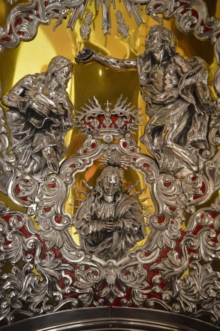 Relieve de orfebrería sacra en plata y oro con detalles cincelados.